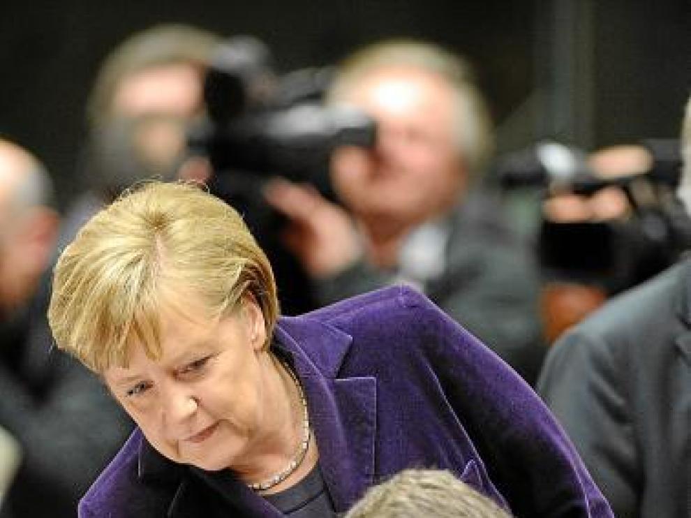 La canciller Angela Merkel se acerca a Zapatero, ayer.