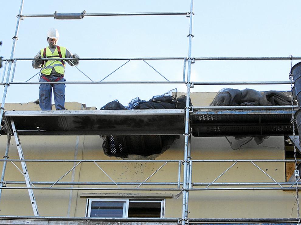 Los operarios están trabajando en la colocación del andamio sobre la fachada que quedó en pie