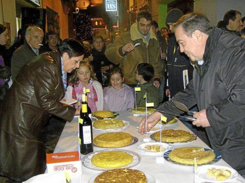 Los vecinos se disponen a probar algunas de las tortillas del concurso.