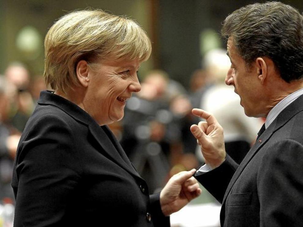 La canciller alemana, Angela Merkel, conversa con el presidente francés, Nicolas Sarkozy, ayer en Bruselas.