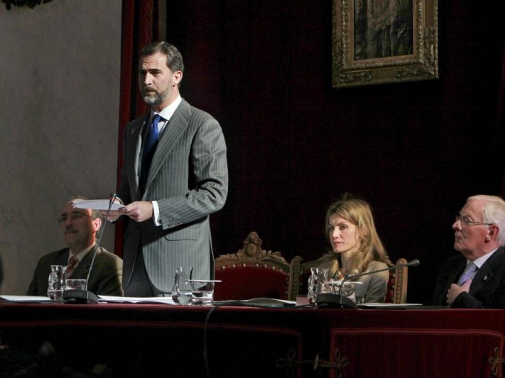 El Príncipe pronuncia su discurso junto a la prencesa Letizia y el director saliente de la RAE, Víctor García de la Concha.
