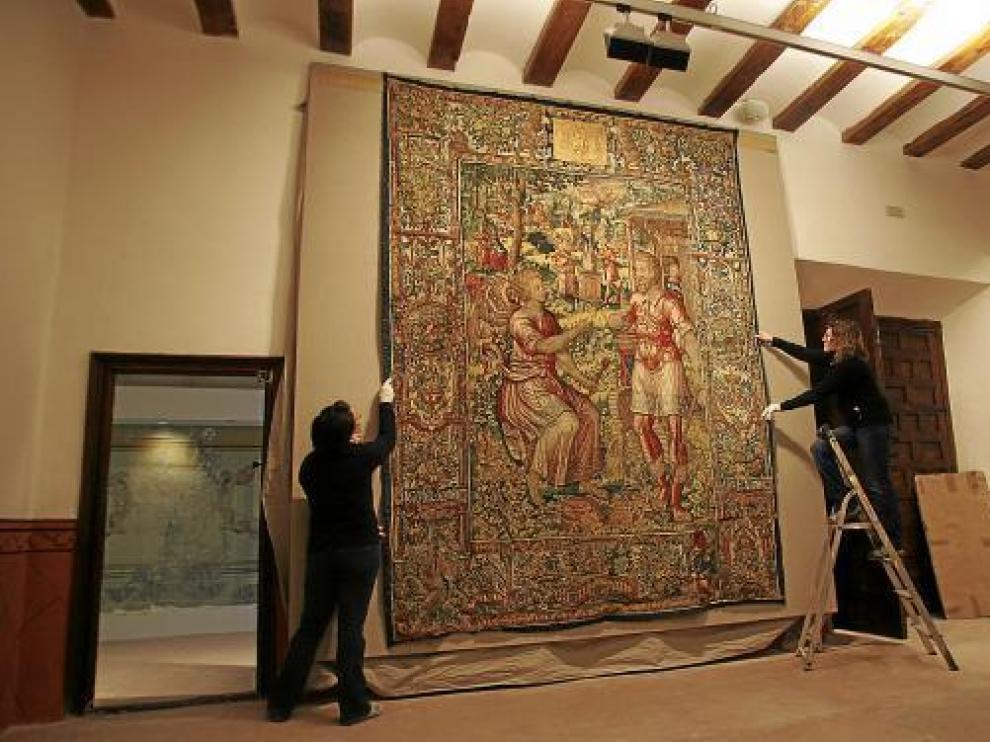 Dos trabajadoras de la Fundación colocan un tapiz en el Museo Episcopal.