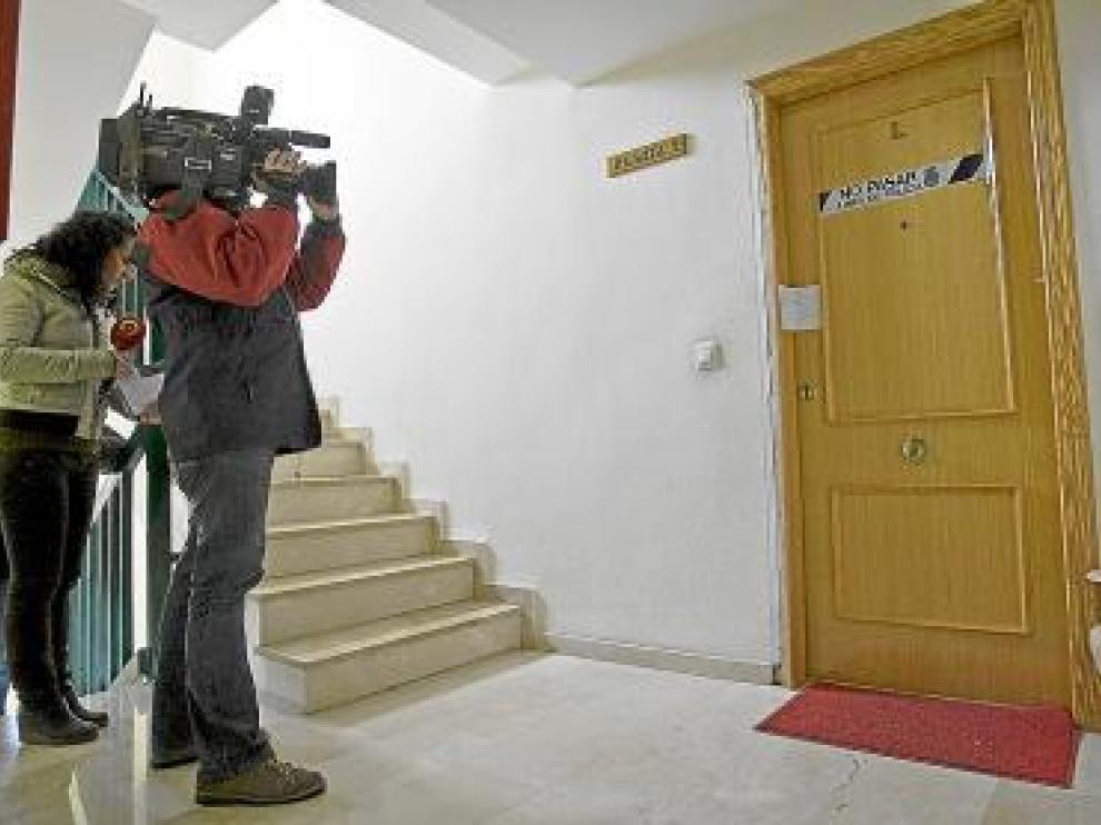 Dos periodistas, en la puerta de entrada de la vivienda.