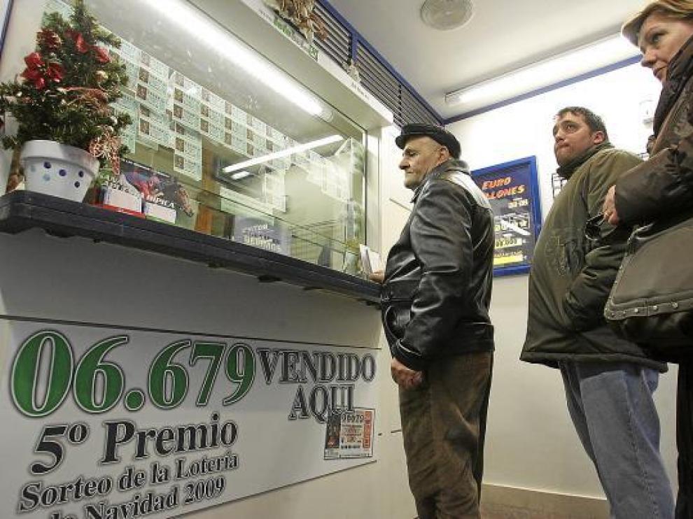 Varios clientes hacen cola ayer en una administración de lotería de Huesca.