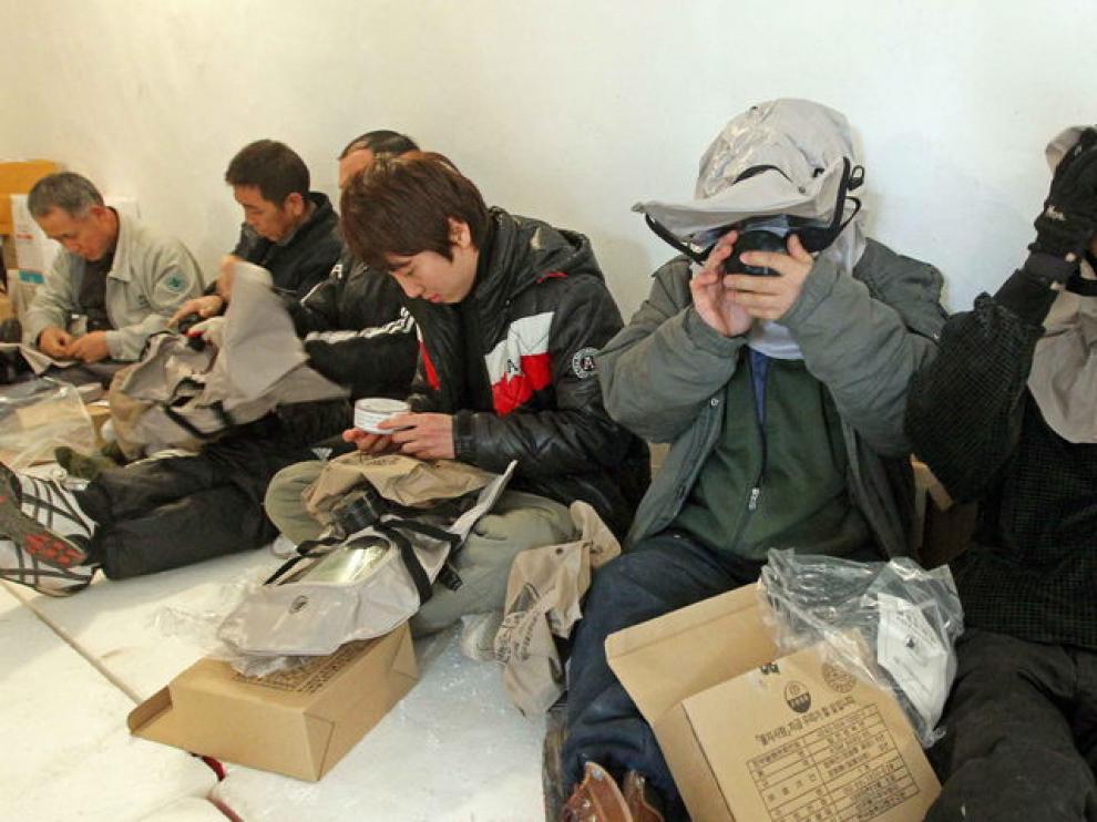 Varias personas se ponen máscaras antigas en el interior de un refugio en la Isla Yeonpyeong