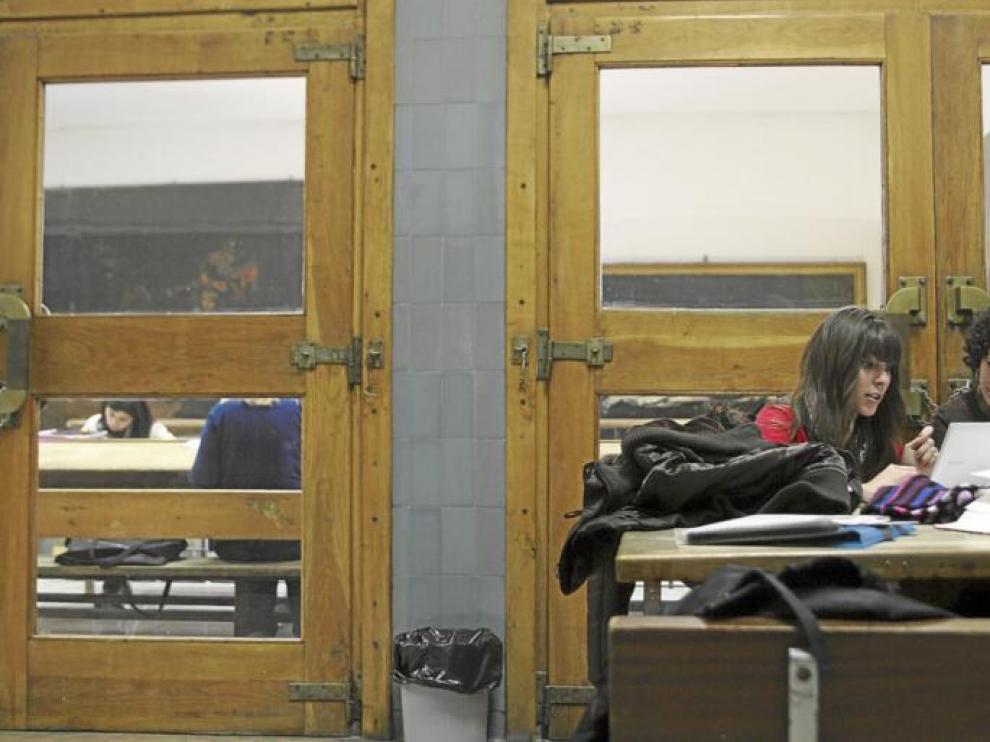 Dos jóvenes repasaban ayer sus apuntes en un pasillo de la Facultad de Filosofía y Letras, otros lo hacían dentro de la sala de estudio.