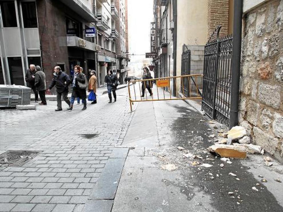 Piedras y cal desprendidas de la cornisa de la iglesia, permanecían ayer en la acera.