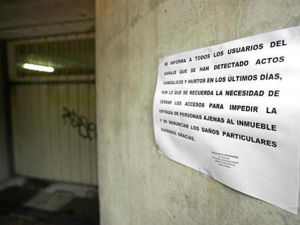 Un cartel alerta a los vecinos de un bloque del Polígono 24 de Huesca de los hurtos en garajes.