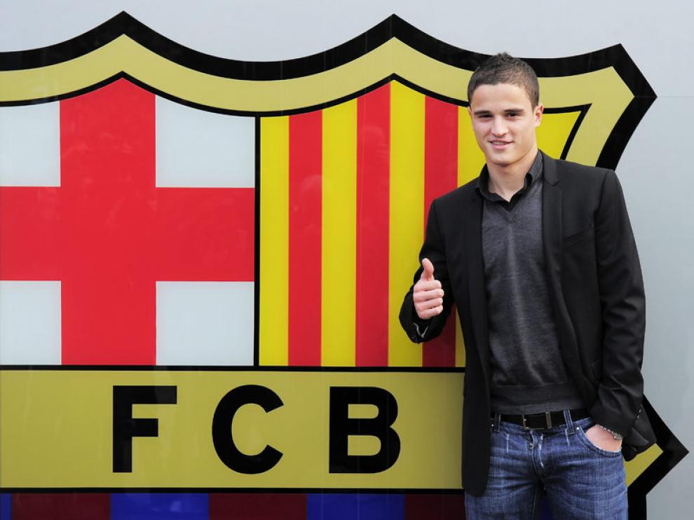 Afellay posa con el escudo del Barça tras él
