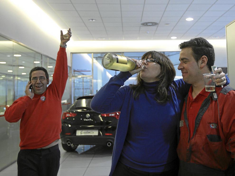 Trabajadores de Alfa Romeo celebran que les ha tocado el 2º premio de la lotería. Algunos empleados tienen más de tres décimos.