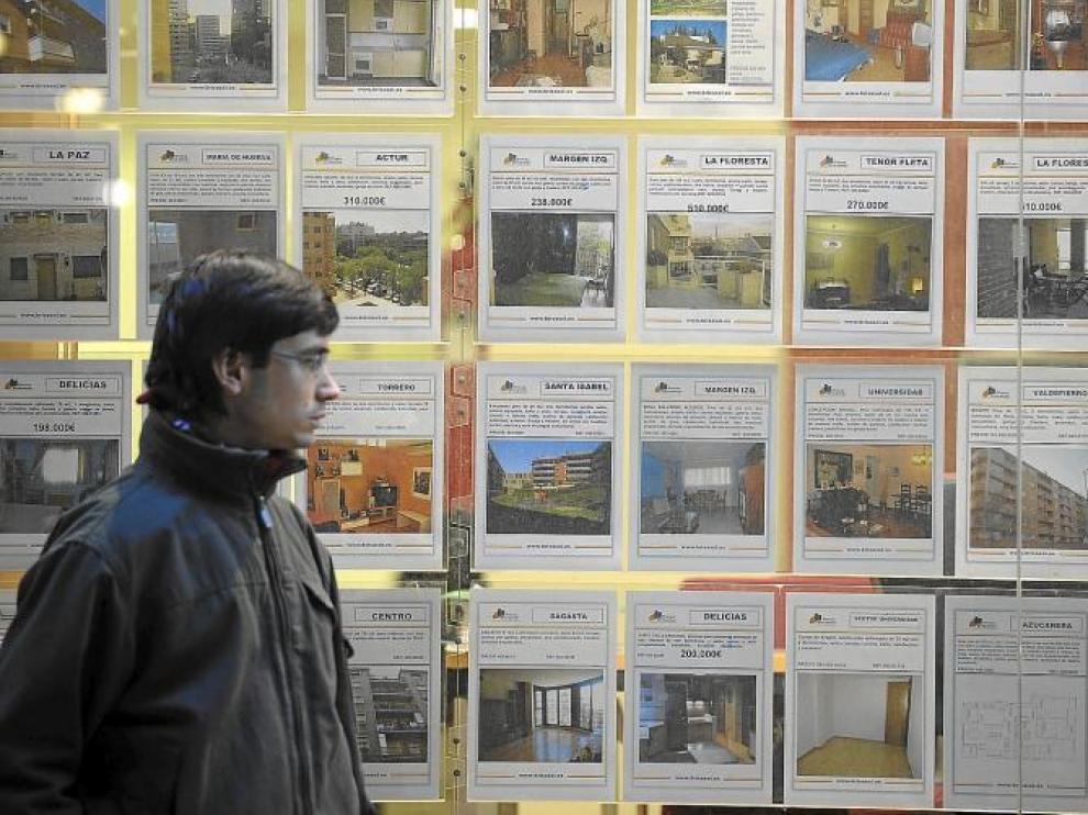 Un ciudadano pasando por delante de una inmobiliaria