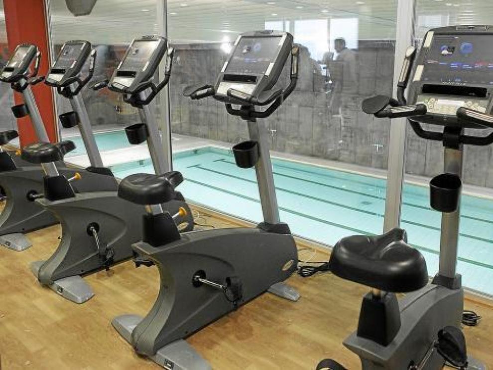 La sala de bicicletas tiene una cristalera con vistas a la piscina climatizada.