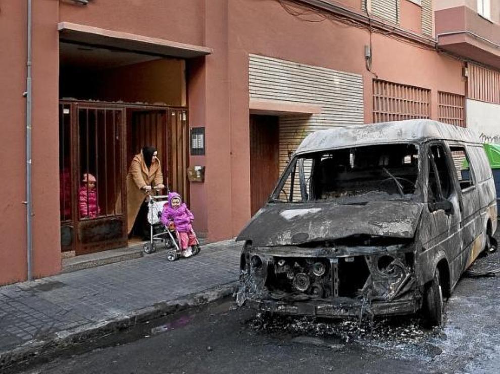 Estado de una furgoneta tras el incendio de unos contenedores durante la noche del sábado.