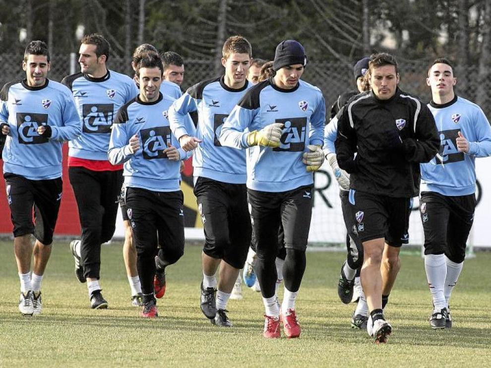 Algunos de los futbolistas de la Sociedad Deportiva Huesca, durante el entrenamiento de ayer en el IES Pirámide.