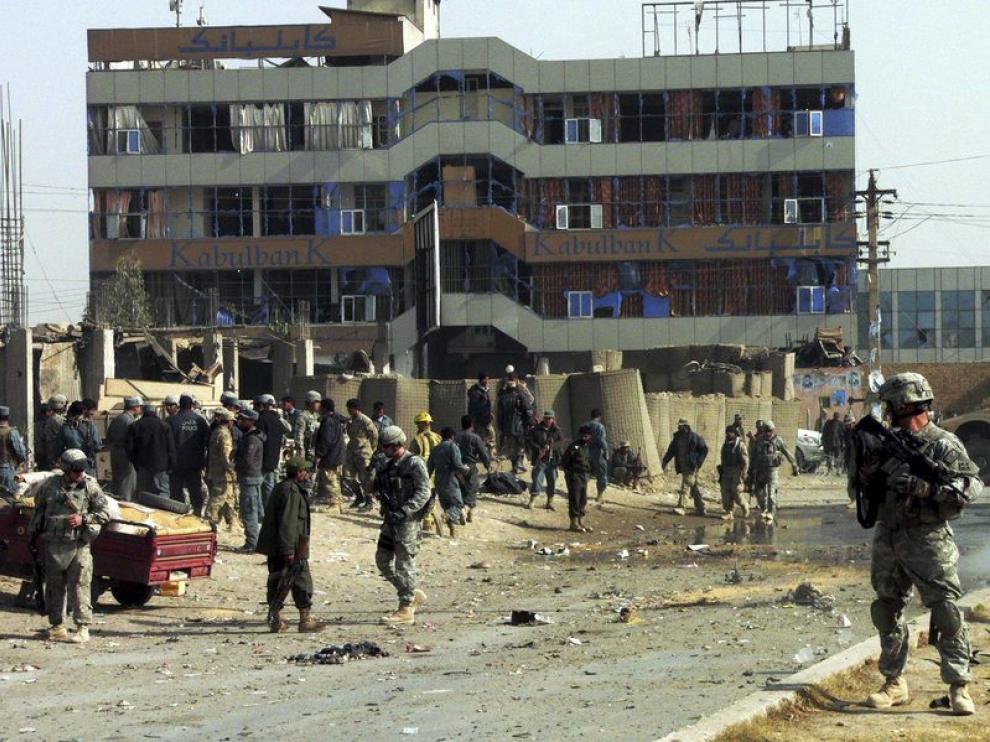 Los soldados estadounidenses y afganos inspeccionan el lugar en el que ha sucedido el atentado suicida, hoy en Kandahar