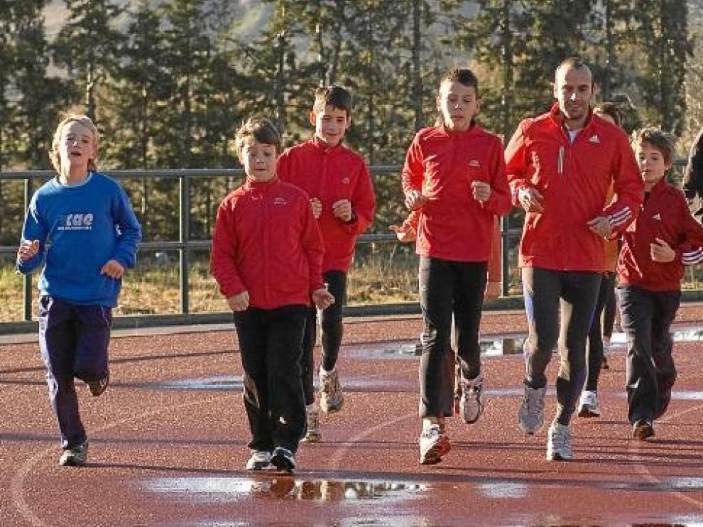 Roberto García y Toni Abadía, con un grupo de atletas en las pistas de la Ciudad Deportiva de Ejea el año pasado.
