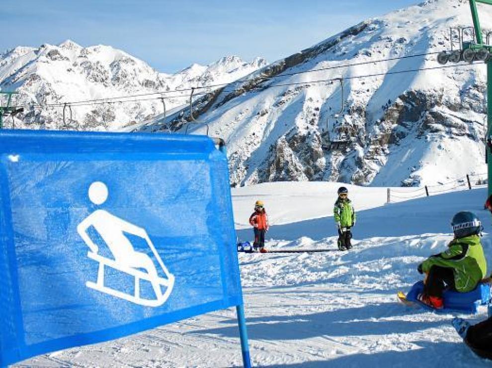 Personal de la estación de Panticosa ayuda a descender a unos niños en la pista exclusiva para trineos.