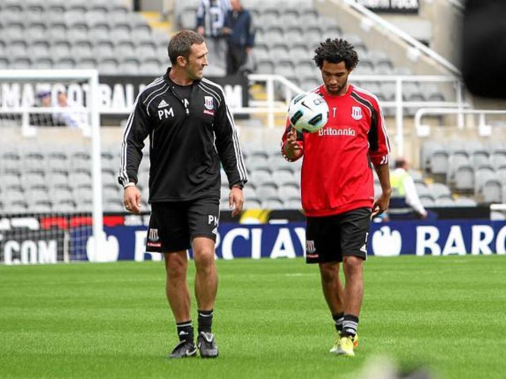 Pennant, tras un calentamiento, junto a uno de los técnicos del Stoke City.