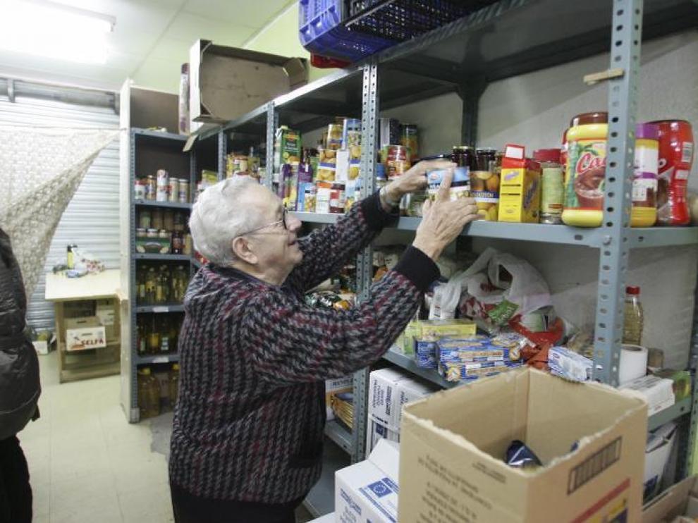 Un voluntario, en la sede de San Lorenzo, coloca los diferentes alimentos que han recibido.