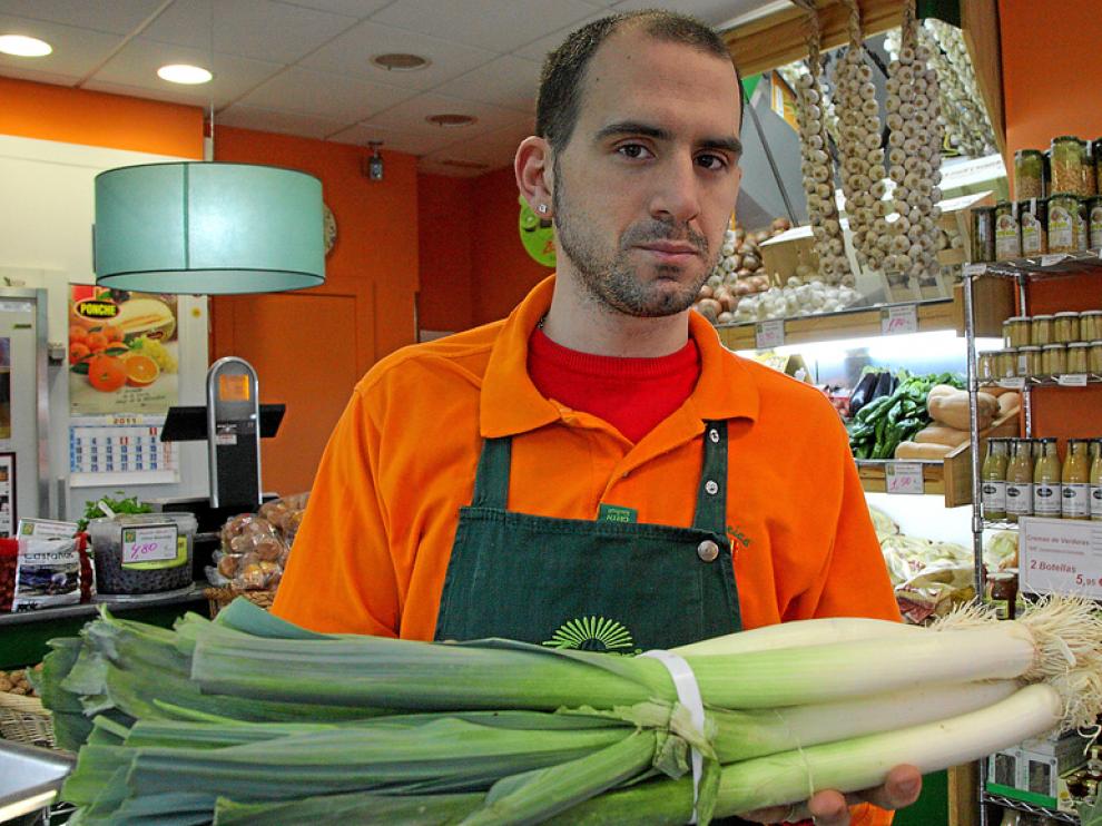 Eric Martín muestra un manojo de puerros en la Frutería Alfredo Martín, de Zaragoza.