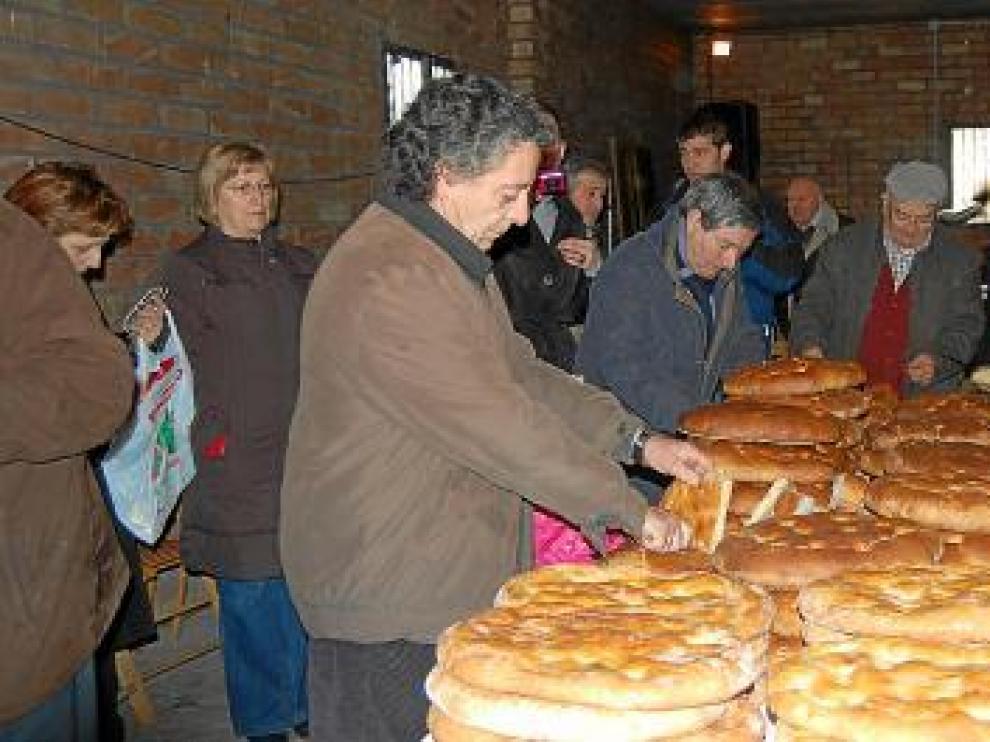 Tras la bendición, varios vecinos cortan las tortas y las reparten entre el público.