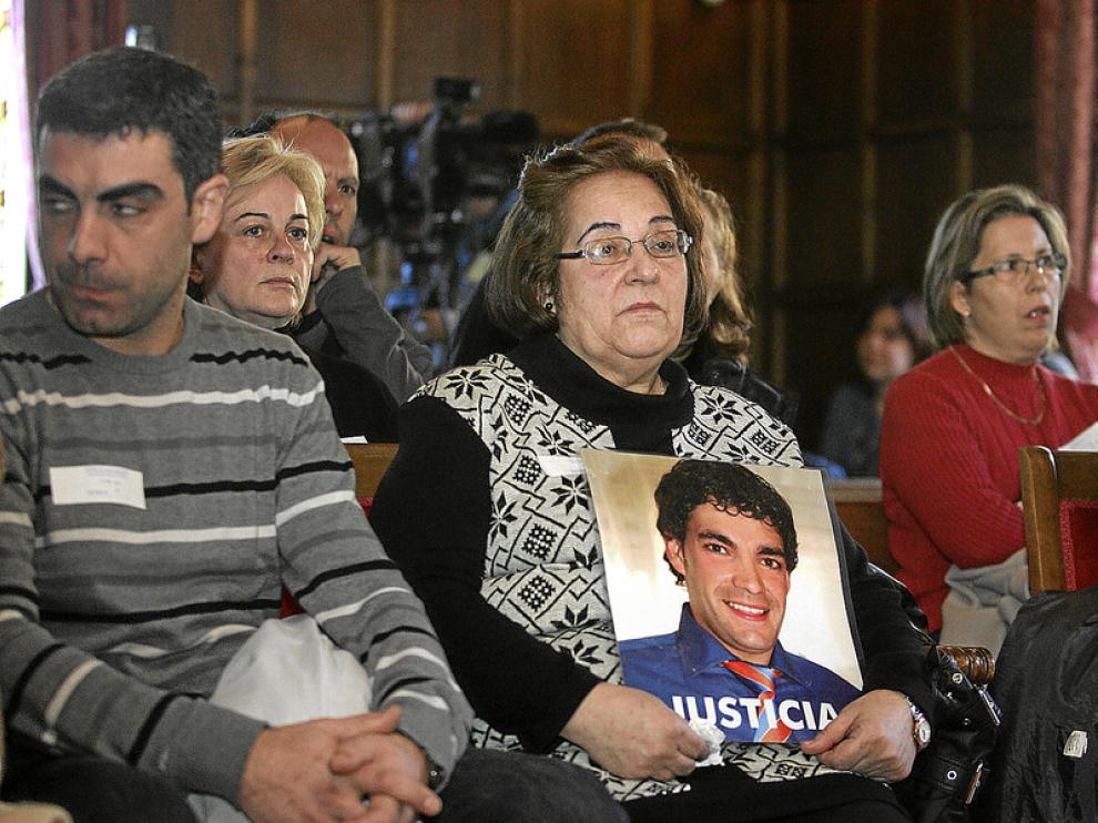 Julia Bernad, sentada entre el público, abraza la foto de su hijo en la que pide Justicia.