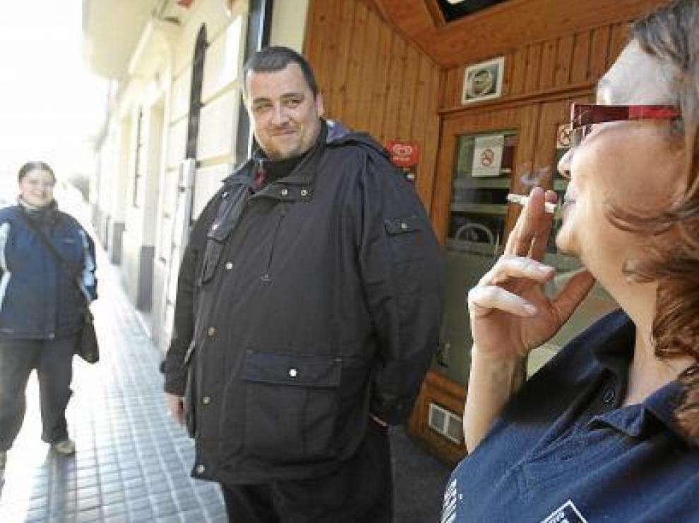 Una fumadora a la puerta de un bar.