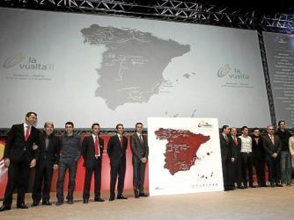 Ciclistas y autoridades posan junto al recorrido de la Vuelta.