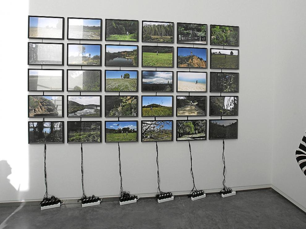 Alberto Gusi muy cerca de una espectacular instalación seriada de fotografías.