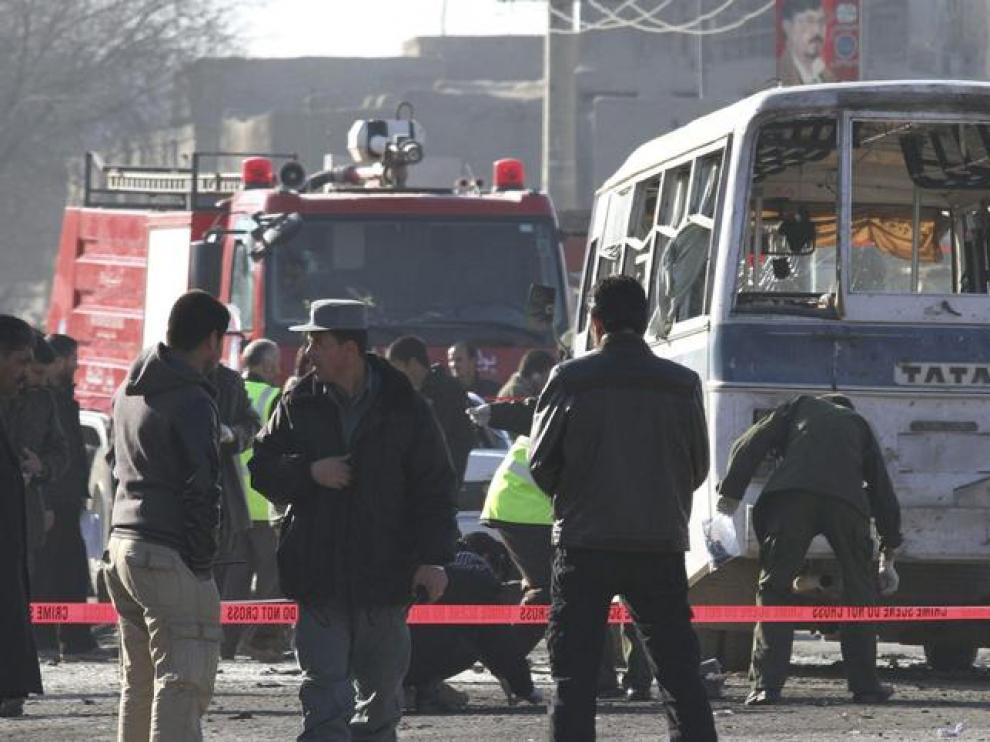 Agentes de seguridad inspeccionan el furgón que fue atacado hoy en Kabul