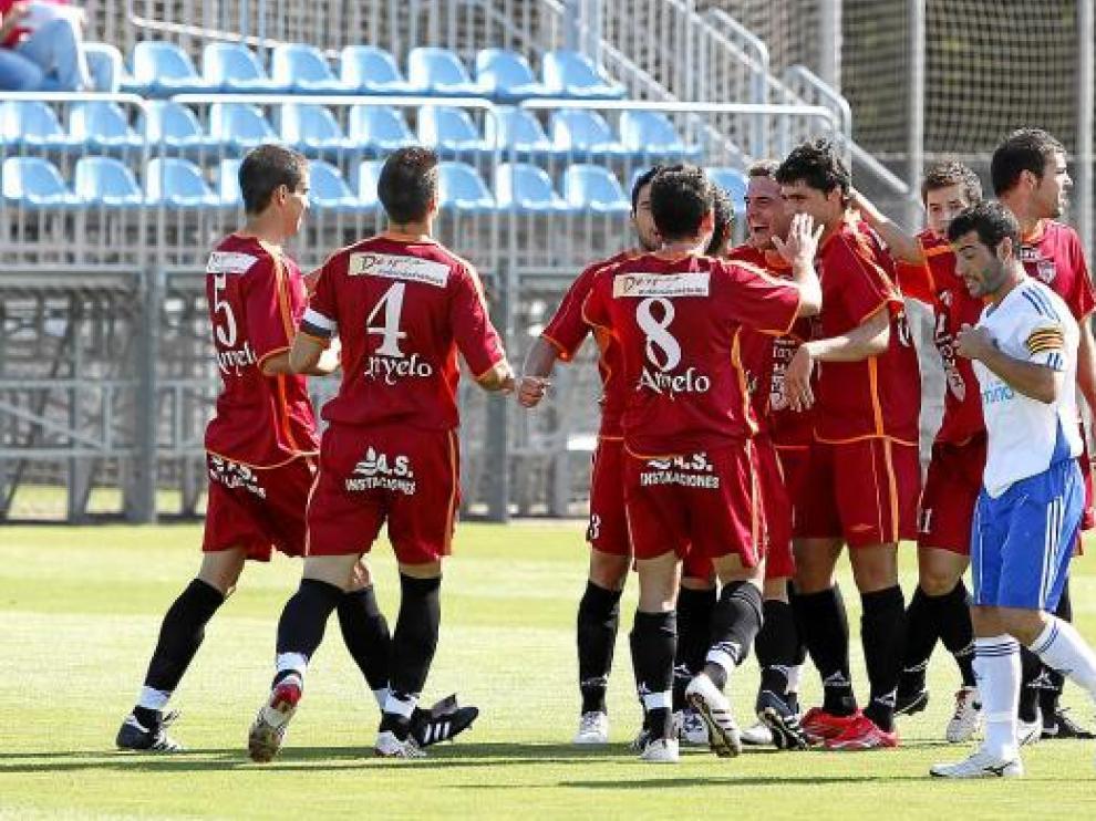 Los jugadores del Calatayud celebran un gol mientras Adrián Barba se lamenta.