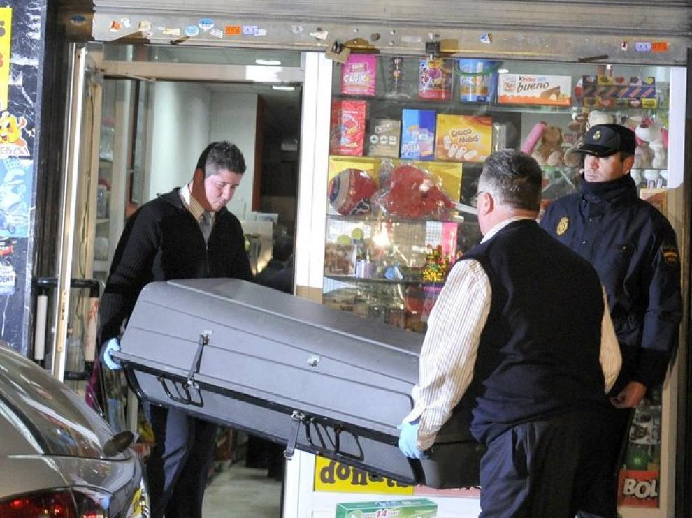 Miembros de la funeraria retiran el cuerpo de la mujer del establecimiento en el que trabajaba