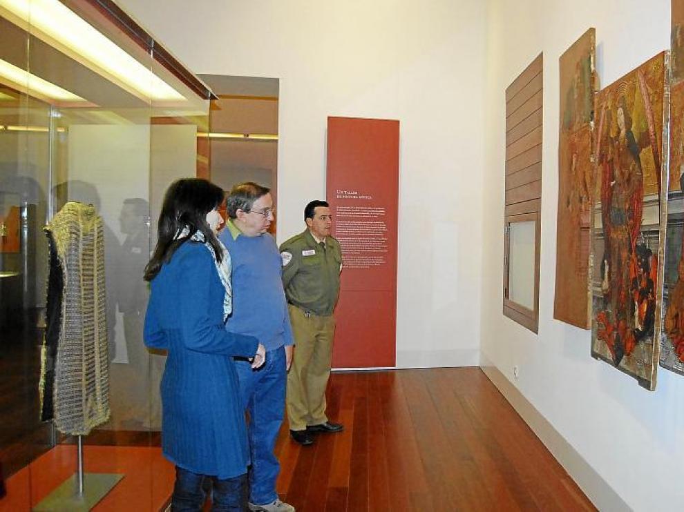La guía del Museo Diocesano de Barbastro-Monzón explica las tablas pictóricas de estilo gótico a uno de los visitantes.
