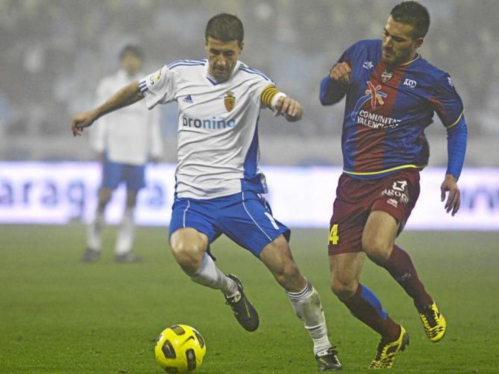 Gabi protege una pelota ante la acometida del centrocampista rival, Xavi Torres.