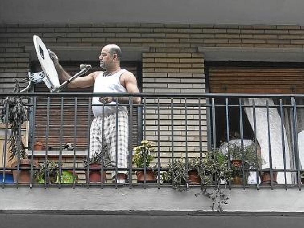 Un vecino limpia los restos dejados por el humo del incendio.
