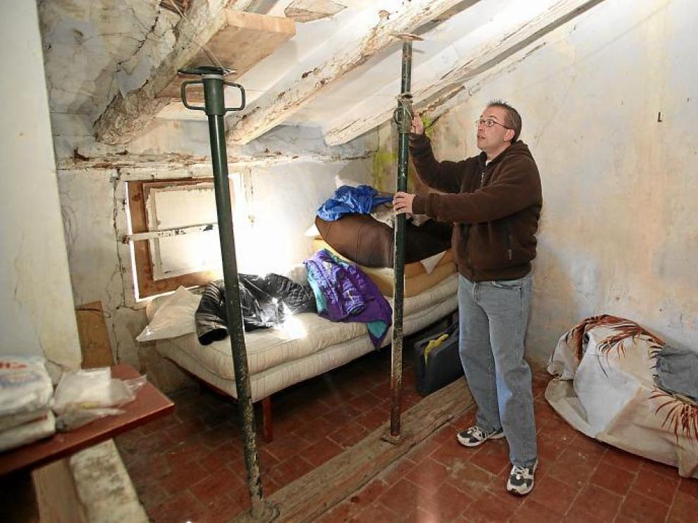David Ruiz apuntala el techo de la casa que ocupa desde hace un año en el barrio Cuevas del Siete. No tiene agua ni luz eléctrica.