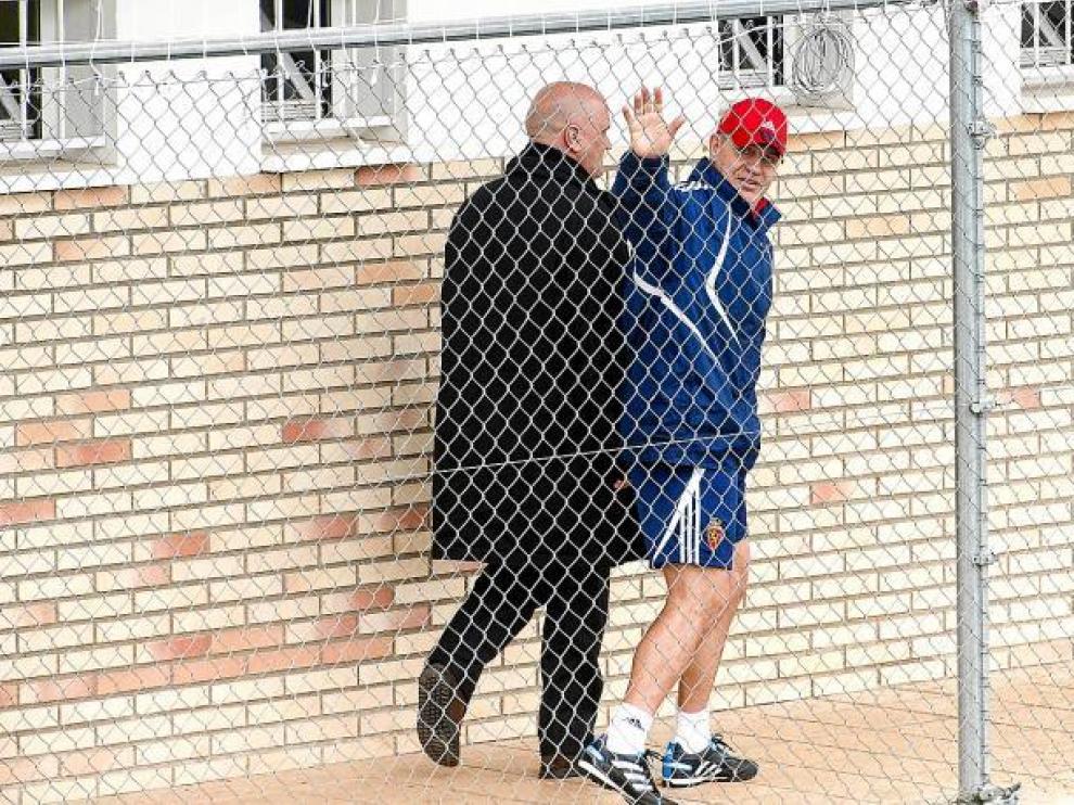 Javier Aguirre, el viernes, saluda acompañado de Pedro Herrera mientras camina por el pasillo de los vestuarios de la Ciudad Deportiva.