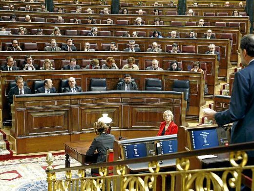 Rajoy (derecha, de espaldas) se dirige al presidente del Gobierno (izquierda), ayer en el Congreso.