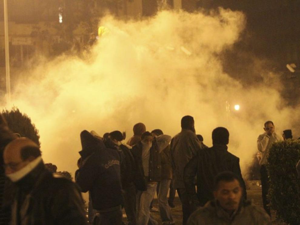 Una nube de gas lacrimógeno cubre a un grupo de manifestantes en El Cairo