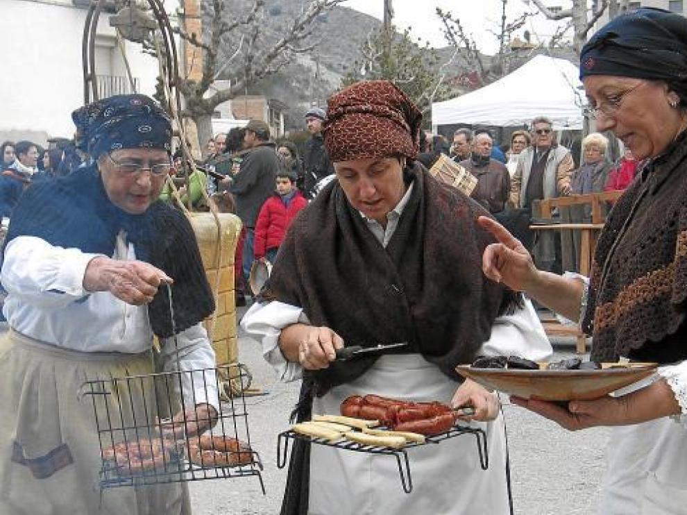 Un grupo de mujeres de la Festa del Tosino de Albelda muestran algunos de los productos del cerdo.