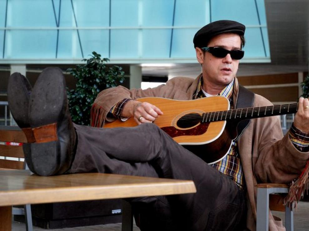 Juan Perro afina su guitarra.