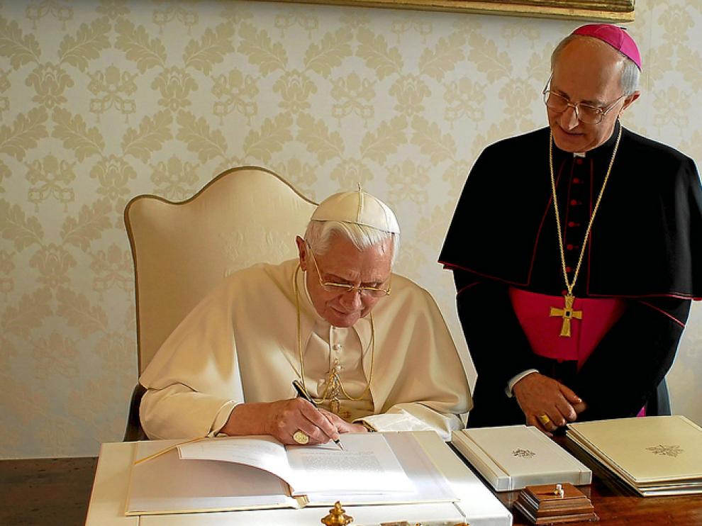 Benedicto XVI escribe en presencia del obispo Fernando Filioni