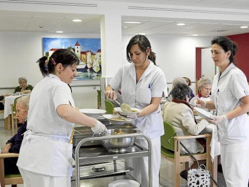 Las auxiliares de la residencia Cai-Ozanam-Oliver, se encargan de servir las comidas.