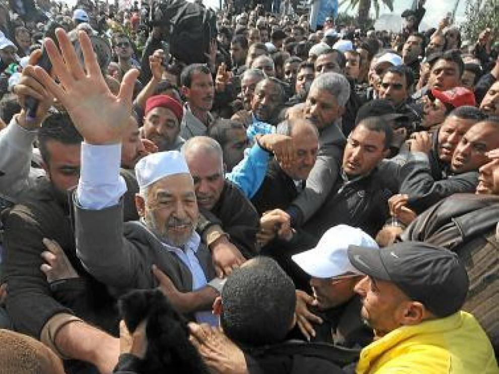 Gannuchi, con gorro blanco, rodeado de seguidores en Túnez.