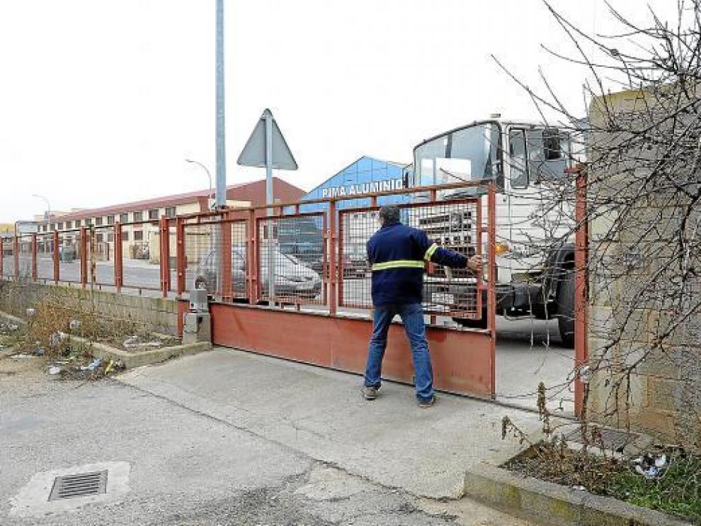 Un operario abre la puerta de la nave municipal a mano por falta de suministro eléctrico.