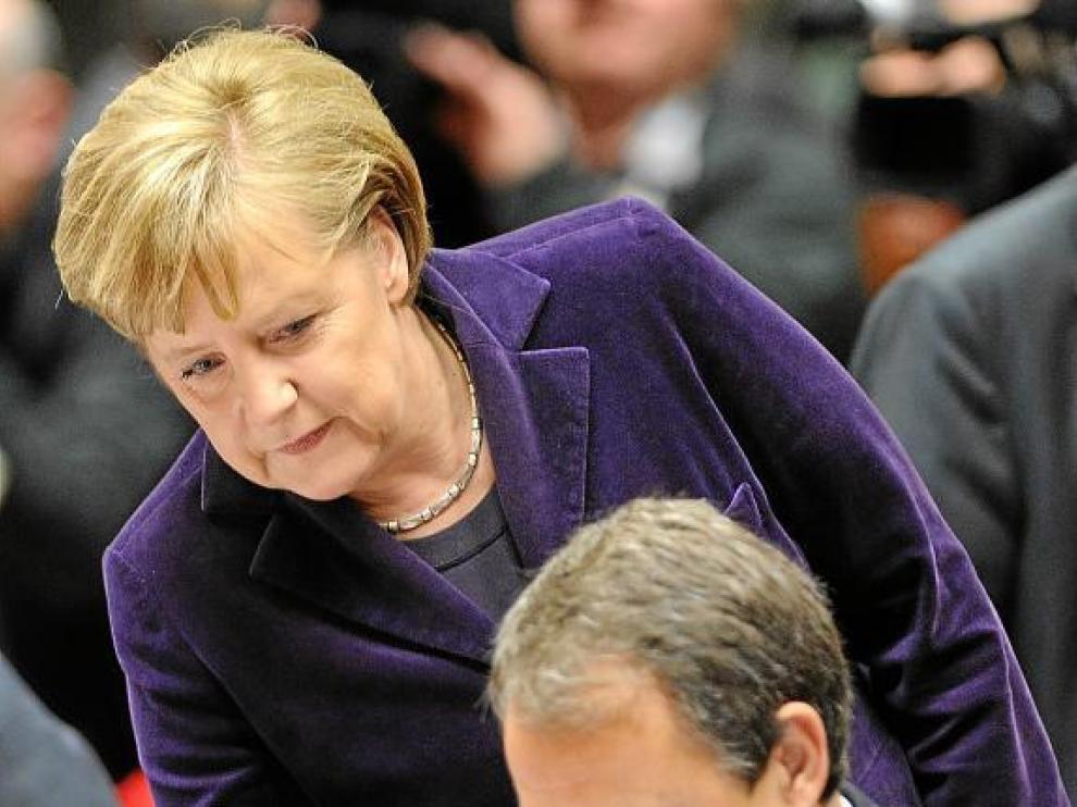 Merkel se acerca a Zapatero en el Consejo Europeo celebrado en Bruselas el 16 de diciembre.