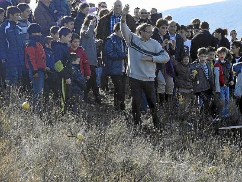 Los vecinos de Ateca, en su mayoría niños, lanzan manzanas a La Máscara en la subida al cerro.
