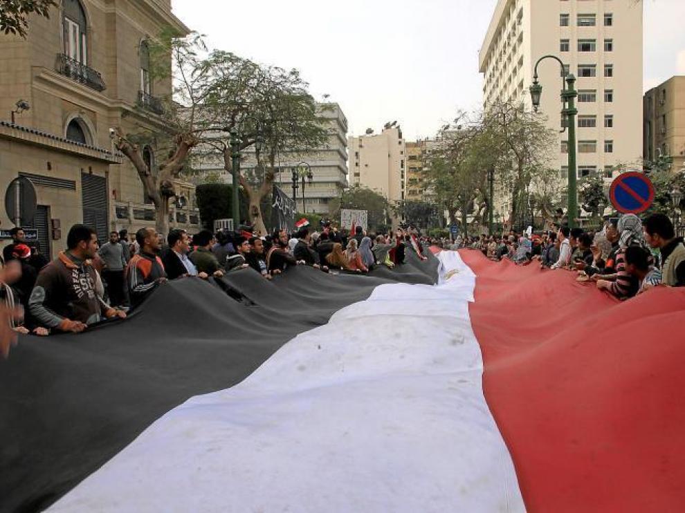 Manifestantes contra Mubarak sostienen una bandera egipcia gigante mientras se concentran en la calle del Parlamento, en El Cairo.