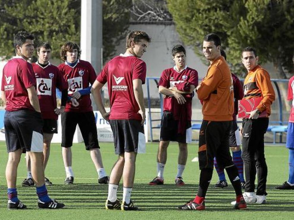 Algunos de los futbolistas del Huesca y parte del cuerpo técnico, en el entrenamiento de ayer.