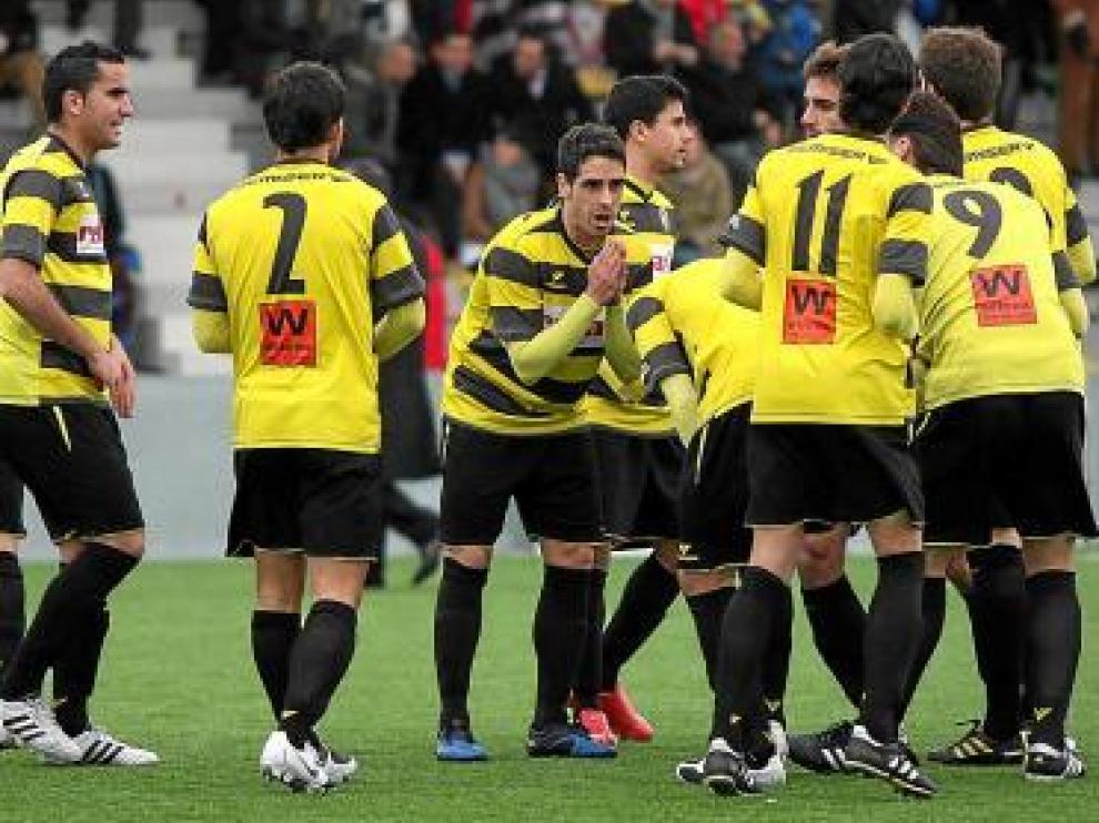 Los jugadores de La Muela dialogan sobre el terreno de juego.